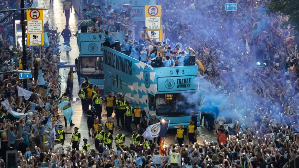 Die Fans und Spieler von Manchester City feiern den historischen Dreikampf im Regen.